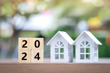 2024 Happy New Year background. Plan and manage for new home, new year budget, tax, loan, real estate, property investment, Business and financial concept. Two house and 2024 wooden blocks number. 