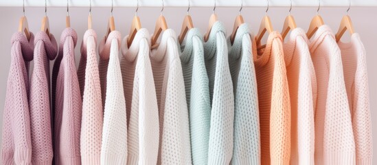Aufkleber - Sweaters in pastel colors hang on white hangers