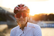 © nuclear_lily - Man is wearing protective helmet, sunglasses and sportswear during evening ride in city.
