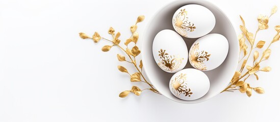 Poster - White eggs adorned with gold foil in bowl Background is white Overhead view Easter theme