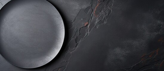 Wall Mural - Copy space above dark stone background with empty black plate Overhead view