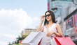 Asian woman shopping bags wear sunglasses lifestyles with buying consumerism at outdoor department store