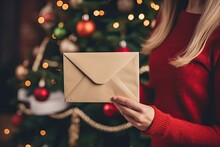 Woman Hand Holding And Receiving A Craft Envelope Eve Festal Day At Decorated Christmas Home Indoors. Letter To Santa Claus. Postal Service.