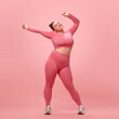 © Lustre Art Group  - Full length happy young attractive plus size active woman in pink top and leggins warm up, training armes isolated studio background.