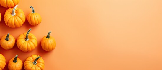 Poster - Top view of orange pumpkins on a colored table background Emblematic of autumn Halloween and Thanksgiving Flat lay photo with copy space