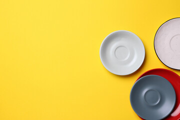 Poster - Clean ceramic plates on yellow background, flat lay. Space for text