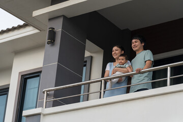 Wall Mural - happy family (father, mother and infant baby) at balcony of house