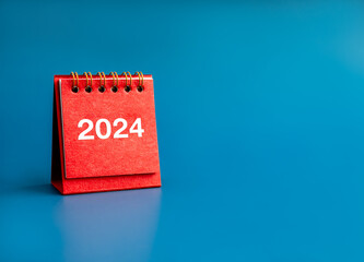 Poster - happy new year 2024 banner background. 2024 white numbers year on red small desk calendar cover stan
