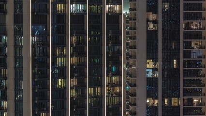 Wall Mural - Tall blocks of flats with glowing windows located in residential district of city aerial timelapse.