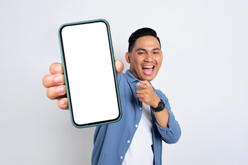 excited young asian man in casual shirt showing smartphone with blank screen isolated on white backg