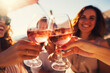 © Jasmina - Group of happy female friends celebrating holiday clinking glasses of rose wine in Santorini