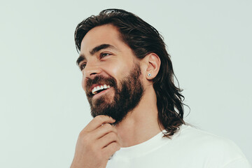 Man with a beard smiling happily in a studio, showing off his perfect look