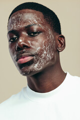 Wall Mural - Practicing skincare with a face wash: Portrait of a young man using a facial cleanser