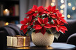 Red Christmas star poinsettia flowers in gold vase on the table in living room in holiday lights background