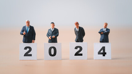 Wall Mural - businessmen miniature figure standing with 2024 for preparation of new year and start new business c