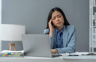 tired business woman sleepy and bored from sitting at a desk for a long time and has office syndrome