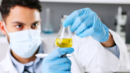 Aufkleber - A thinking young scientist doing research to create a covid cure in a lab. Medical professional using science equipment in a laboratory. A serious male healthcare worker working with a mask.