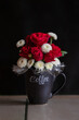 Bouquet of red roses in a coffee cup on a black background