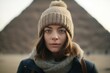 © Markus Schröder - Close-up portrait photography of a content girl in her 30s wearing a warm trapper hat in front of the pyramids of giza in cairo egypt. With generative AI technology