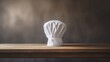 a white chef hat on a wooden table in front of a blurred background, in the style of minimalist starkness, barbizon school, large canvas format, zbrush, algeapunk, made with Generative AI