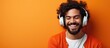© vxnaghiyev - Attractive guy enjoying music with headphones on colored backdrop Room for text
