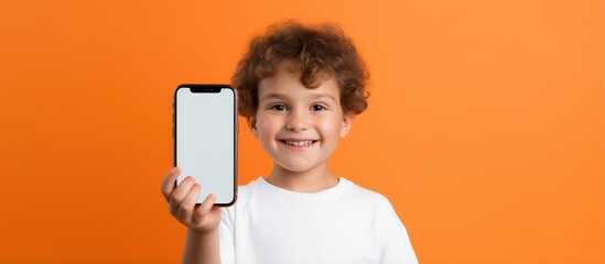 Kid s educational mobile app Little boy with smartphone smiling for school over orange background