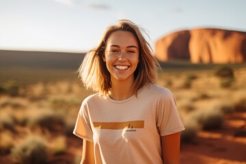 Canvas Print - Medium shot portrait photography of a joyful girl in her 20s wearing a casual t-shirt near the uluru (ayers rock) in northern territory australia. With generative AI technology