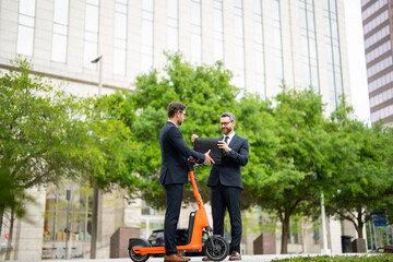 Wall Mural - Two business man in suit talking about finance news standing in modern city. Businessmen walking and talking outdoor in New York city. Confident employee talk with colleague explain new bysiness idea.