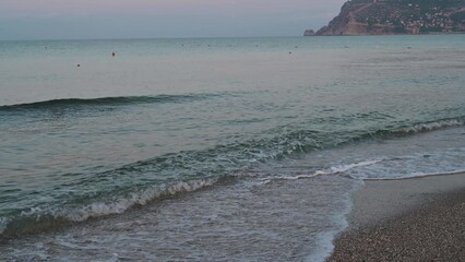 Wall Mural - Waves of Mediterranean Sea rolling to the sandy Turkish beach. Beautiful Turkish evening.