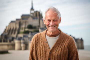 Wall Mural - Medium shot portrait photography of a satisfied mature man wearing a chic cardigan at the mont saint-michel in normandy france. With generative AI technology