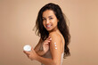 © Prostock-studio - Happy attractive brunette woman applying body cream on shoulder