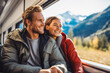 © Tajda - Happy couple in a commercial train going on a vacation, mountains on background