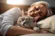 Portrait of Happy adult sleeping woman smiling and cuddling with her pet cat. Peace of mind and love for pets.