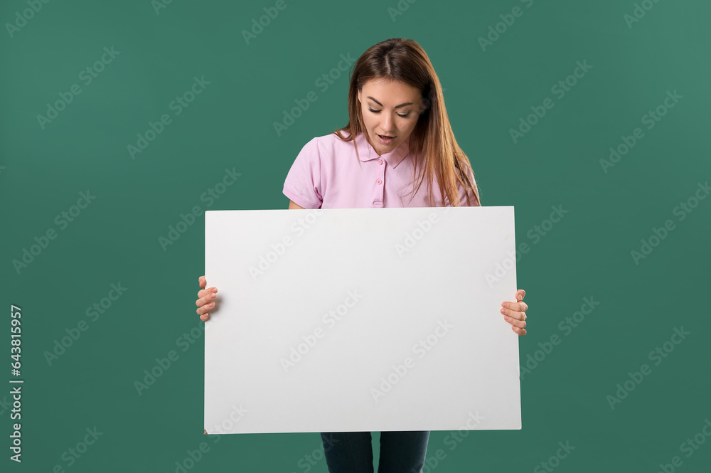 Beautiful woman with big blank poster on green background