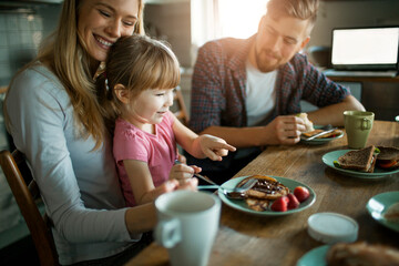 Young Caucasian family having breakfast in the kitchen