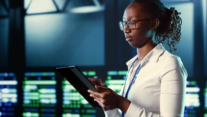 Poster - african american woman walking through server farm rows providing processing resources for different