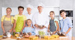 © JackF - Young guy and adult woman cook posing with group of children at cooking master class