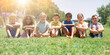 © JackF - Happy team of friends children resting on grass at sunny day in park