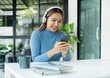 © Orathai - Happy Asian girl wearing headphones listening to music enjoying on smartphone digital. relaxation concepts
