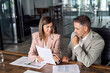 Female busy lawyer or financial advisor consulting older male client investor showing documents at meeting. Two mature business executive colleagues discussing account paperwork report in office.
