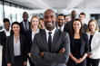 © Acronym - Multiracial diverse business team headed with boss posing to camera. Smiling businesspeople in office. The concept of business.