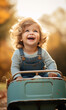 lachender Junge im Herbst mit dem Tretauto unterwegs 
