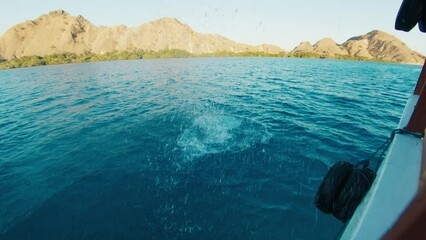 Poster - Woman jumps into the water from the boat, man watches her