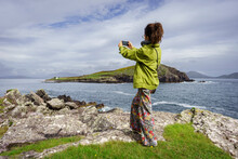 Woman Photographing Horse Island, .Ballinskelligs, Ring Of Kerry, United Kingdom