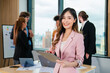 © kelvn - Successful asian businesswoman working and looking camera in a meeting room.