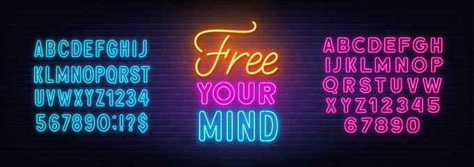 Free Your Mind neon lettering on brick wall background.
