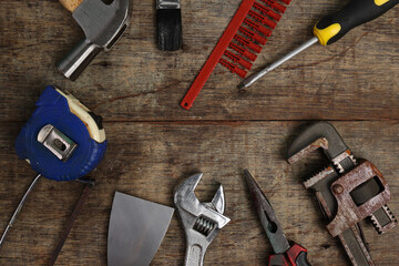 Rusty old tools driver plyer hammer spanner saw on rustic wood background copy space