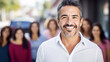 Handsome middle aged mexican man, happy, smiling, with women of the family in background