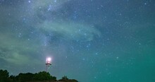 Galaxy Stars In Starry Sky Time Lapse Above The Lighthouse Shining At Night