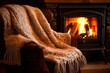 In the living room there is a close-up armchair with a white plaid. A fireplace is burning near it. The concept of warmth and comfort of a country vintage vacation in the forest.